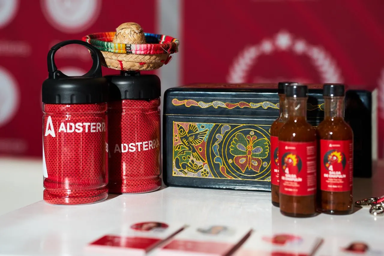 Adsterra branded drinkware and client gifts at a conference