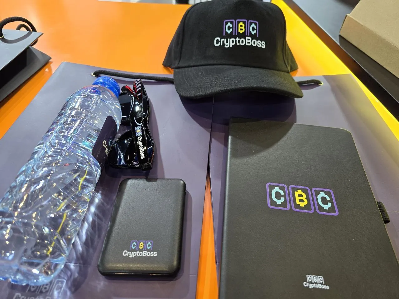 CryptoBoss merchandise kit with cap, bottle and notebook