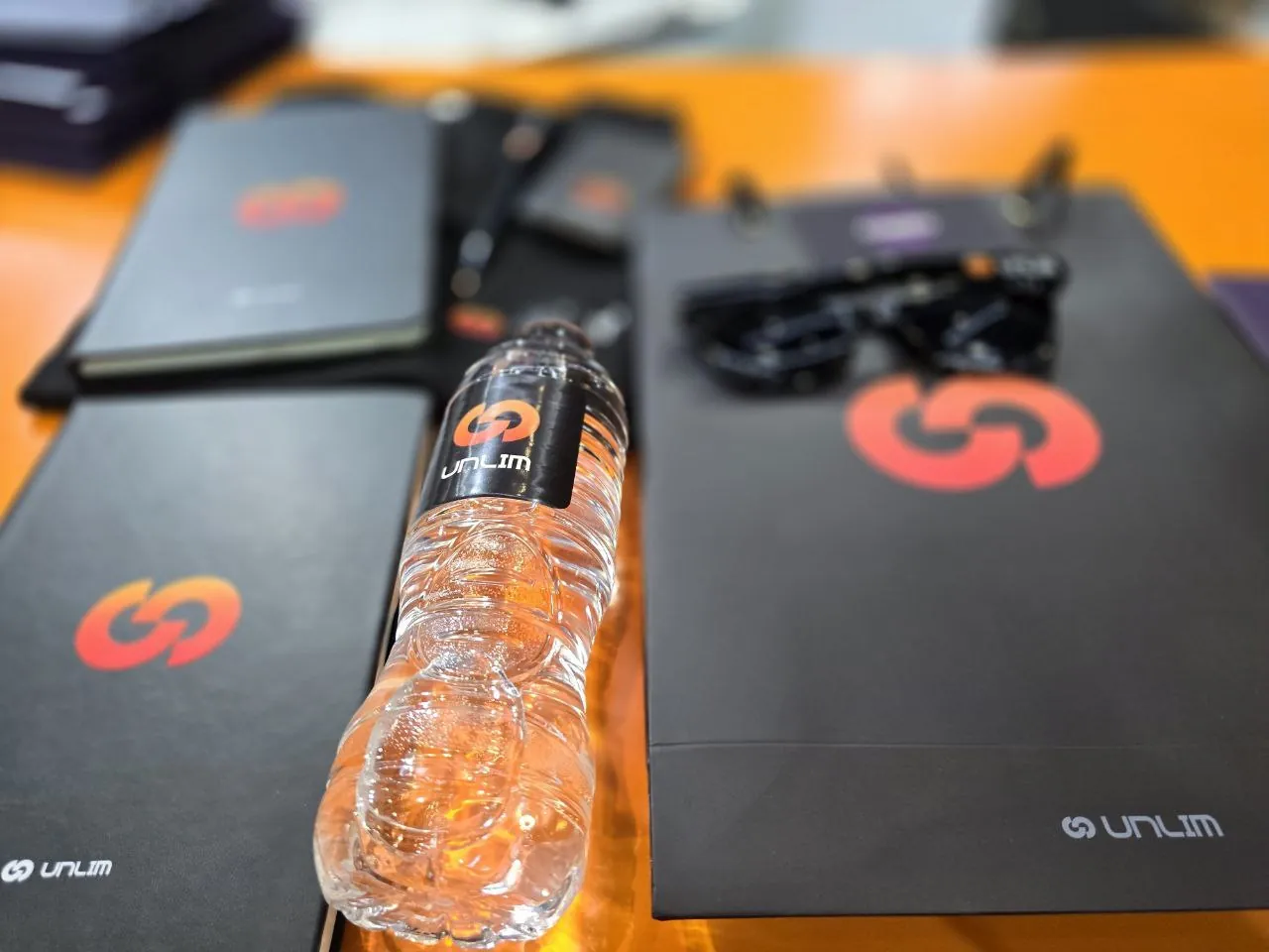 UNLIM branded event materials and water bottle
